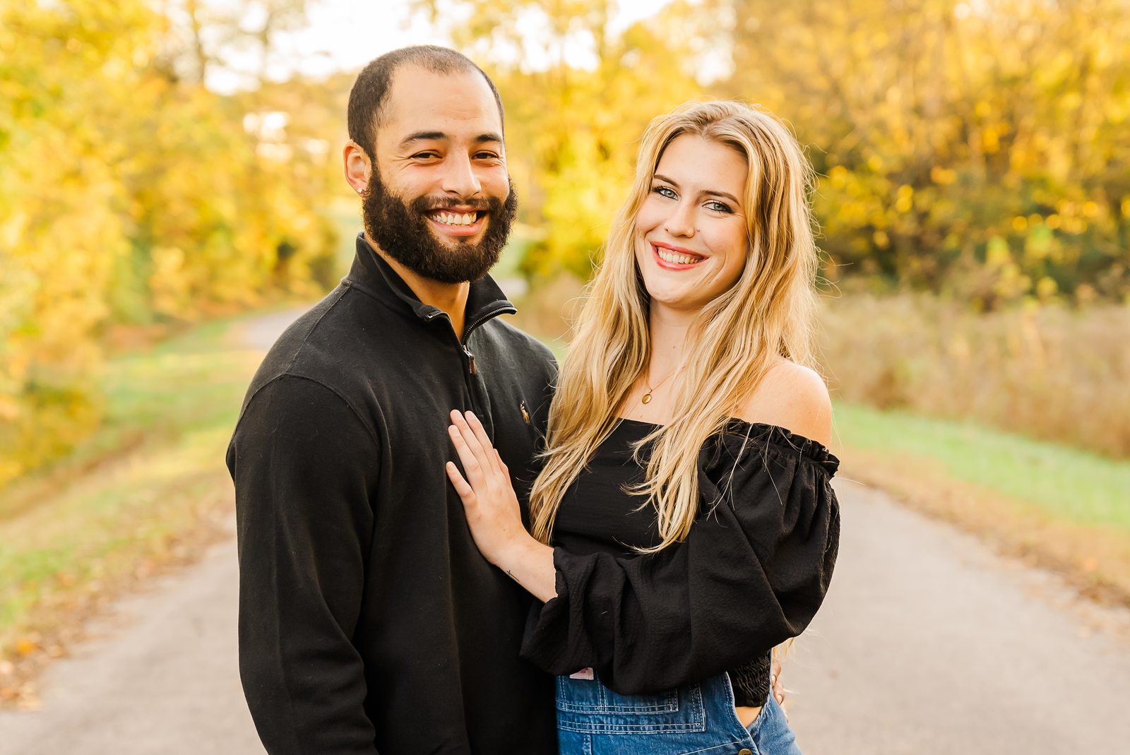 A couple photographed together on a lane in full autumn colour